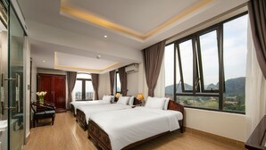 A hotel room with two beds, a desk, and a view of the city. - Tam Coc Nam Hoa Hotel and Spa (Nam Hoa Lu)