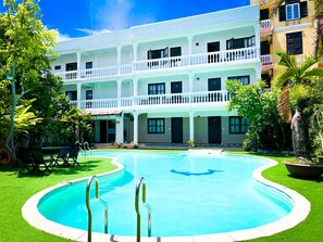 A hotel with a swimming pool, a covered patio, and a two-story building with balconies. - Hai Yen Hotel (Da Nang)
