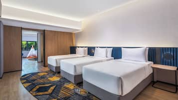 A modern hotel room with two beds, a small table, and a view of a tent outside.