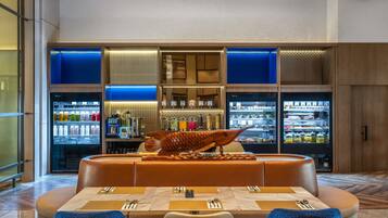 Un restaurant moderne doté d’un bar, de tables dressées et d’une sculpture de poisson décorative.