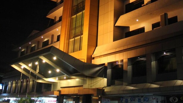 A multi-story building with a modern architectural design, featuring a prominent central vertical element and balconies on each floor. - Kini Pontianak (Pontianak)