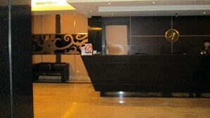 A reception desk with a modern design, a logo on the wall, and a no-smoking sign. - Kini Pontianak (Pontianak)