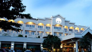 A hotel with a modern design, featuring a prominent logo on the facade, multiple balconies, and a covered entrance area. - Bumi Senyiur (Samarinda)