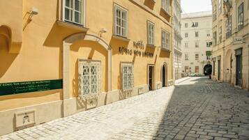 Una calle adoquinada que conduce a un edificio con un letrero que dice 'Hotel König von Ungarn'.