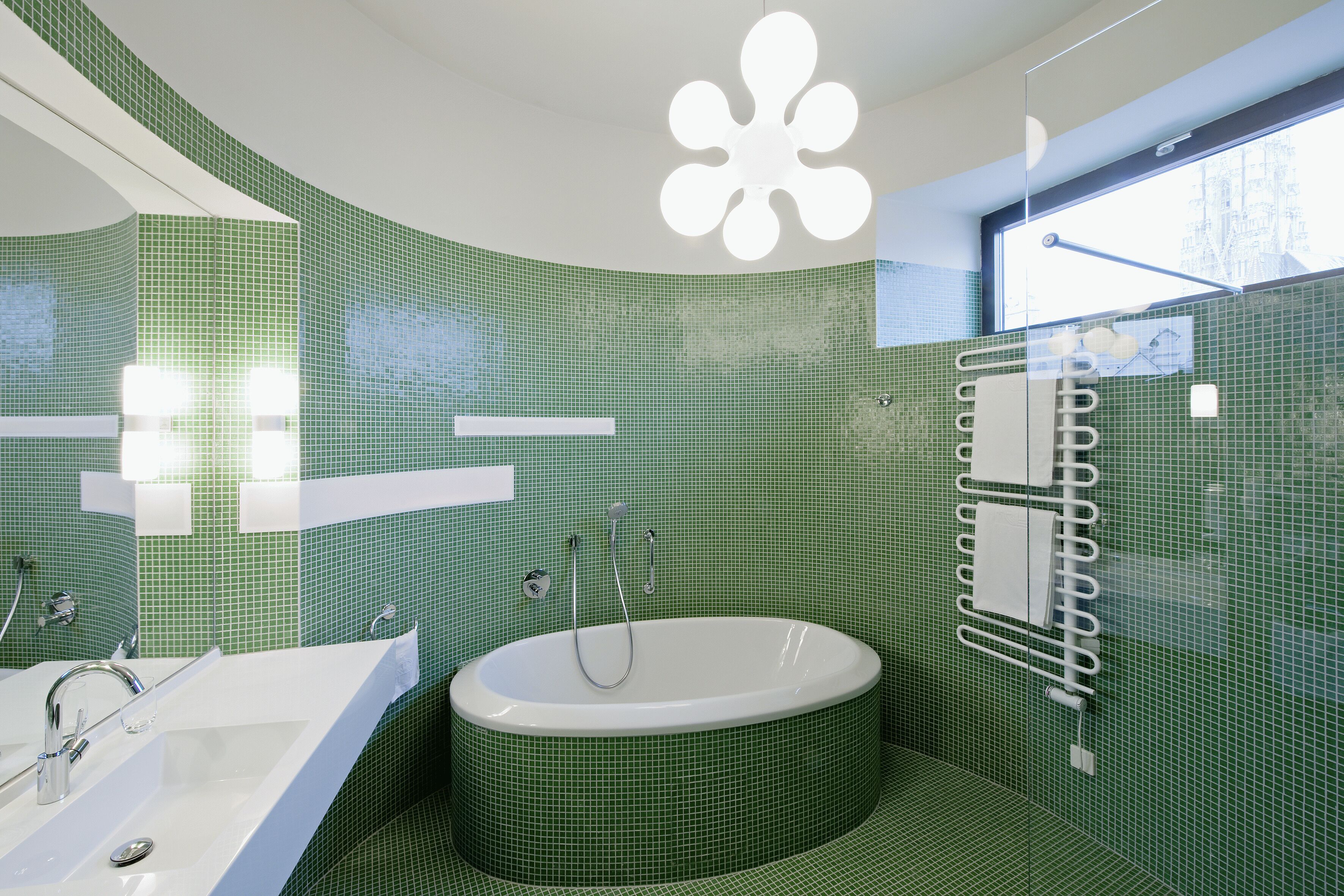 Ein Badezimmer mit freistehender Badewanne, einem Waschbecken und einer Duschkabine aus Glas.