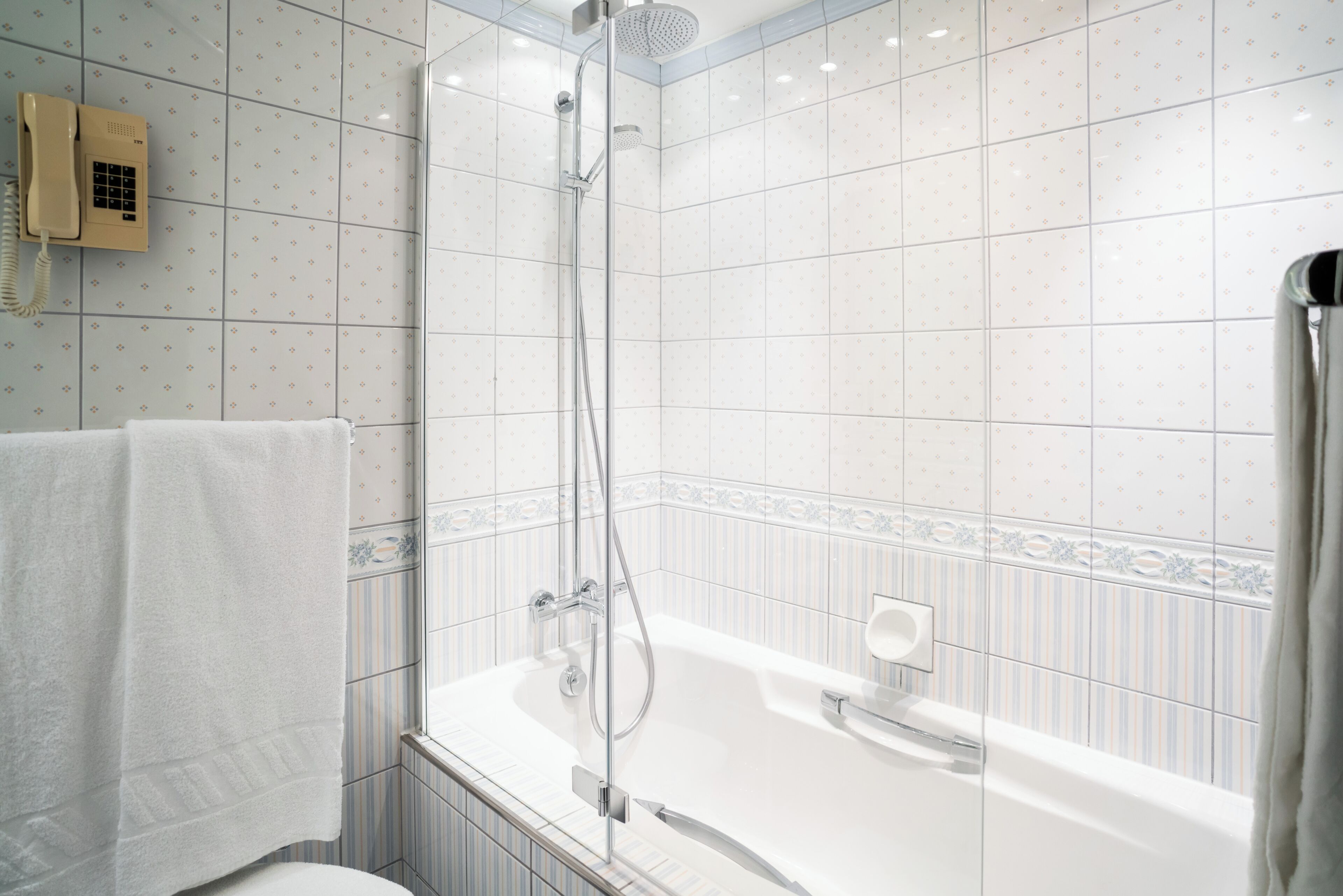 Et moderne badeværelse med bruseniche, badekar og toilet.