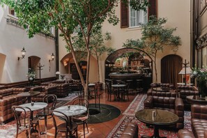 A spacious indoor area with leather seating, a bar, and a variety of tables and chairs. - König von Ungarn (Vienna)
