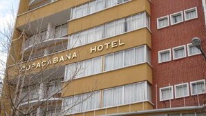Un edificio de hotel de varios pisos con balcones y un letrero que dice 'UPACABANA HOTEL'.