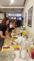 Una mesa de buffet con diferentes opciones de comida y un televisor al fondo.