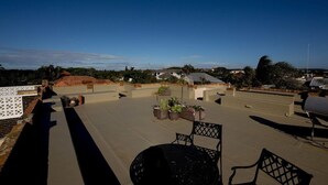 A rooftop patio with outdoor furniture, potted plants, and a barbecue grill. - Harewood Lodge (East London)