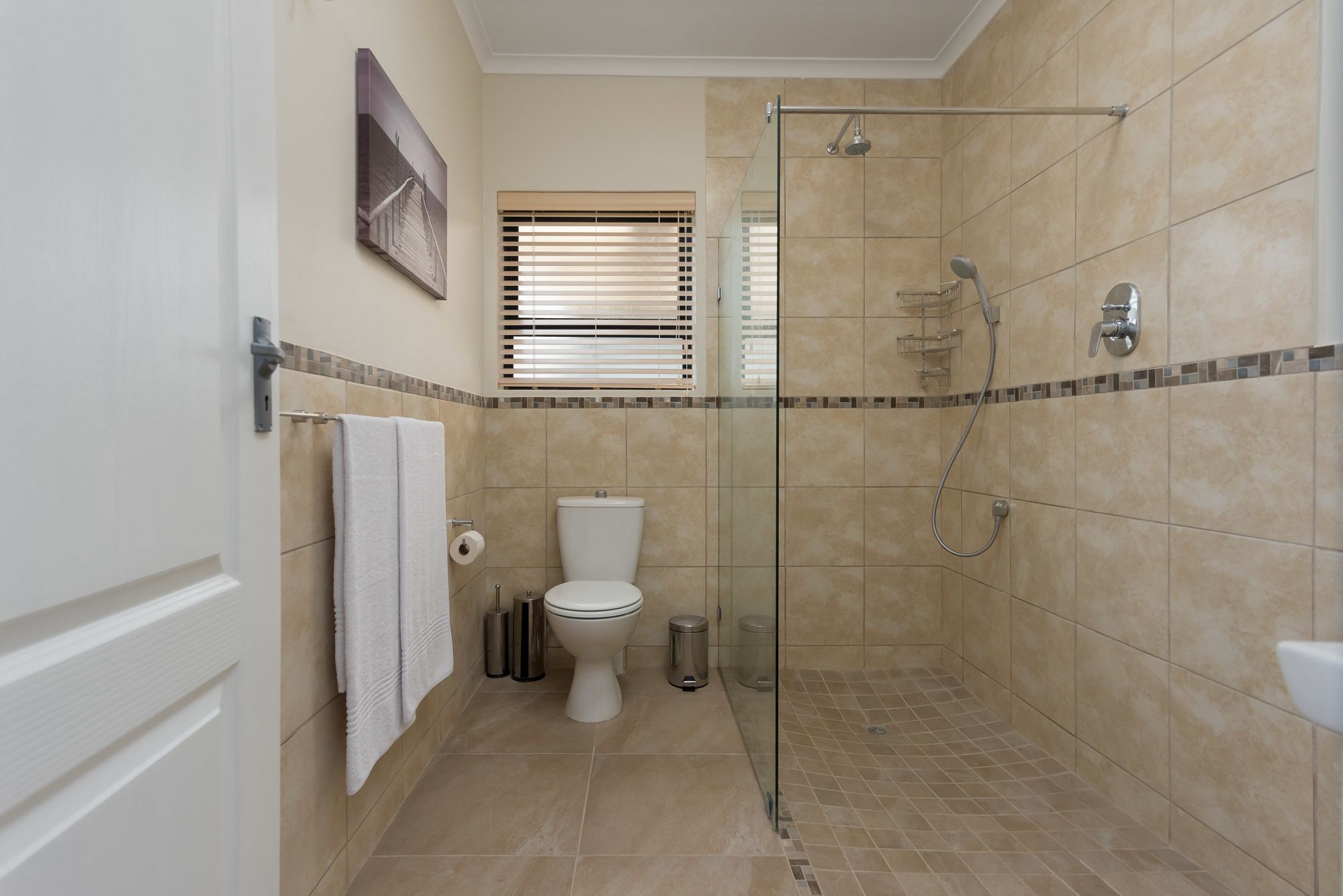 A bathroom with a glass-enclosed shower, a toilet, and a bidet.