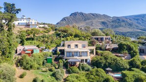 A residential area with multiple houses, a swimming pool, and a mountainous backdrop. - Constantia Vista (Cape Town)