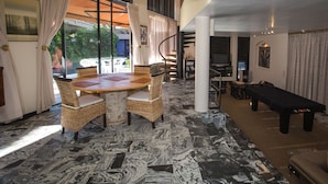 A spacious living area with a dining table, chairs, a pool table, and a view of the outdoors. - Constantia Vista (Cape Town)