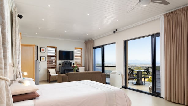 A hotel room with a large bed, a sofa, a TV, and a balcony with a view. - Constantia Vista (Cape Town)