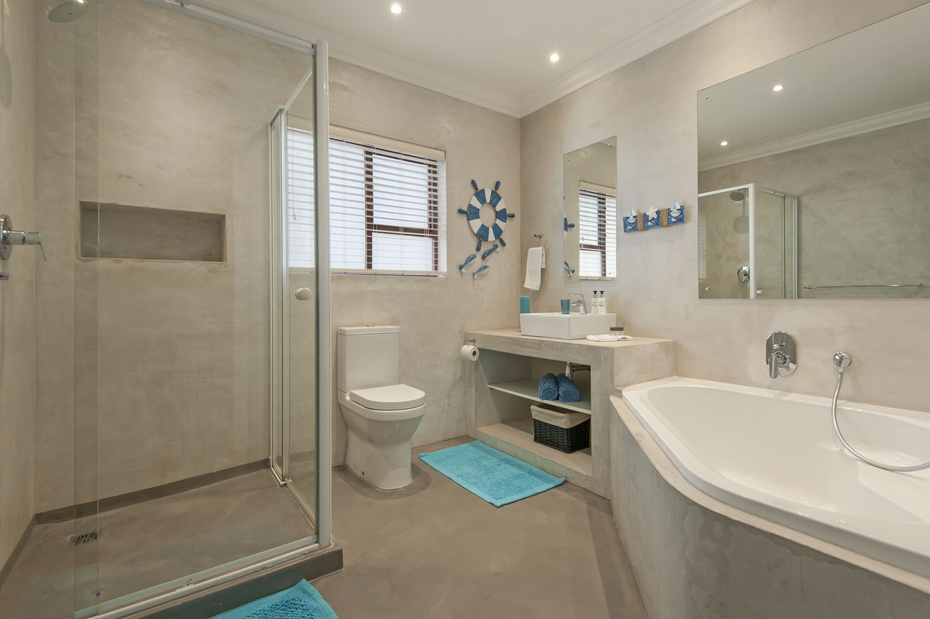 A modern bathroom with a walk-in shower, toilet, and bathtub.