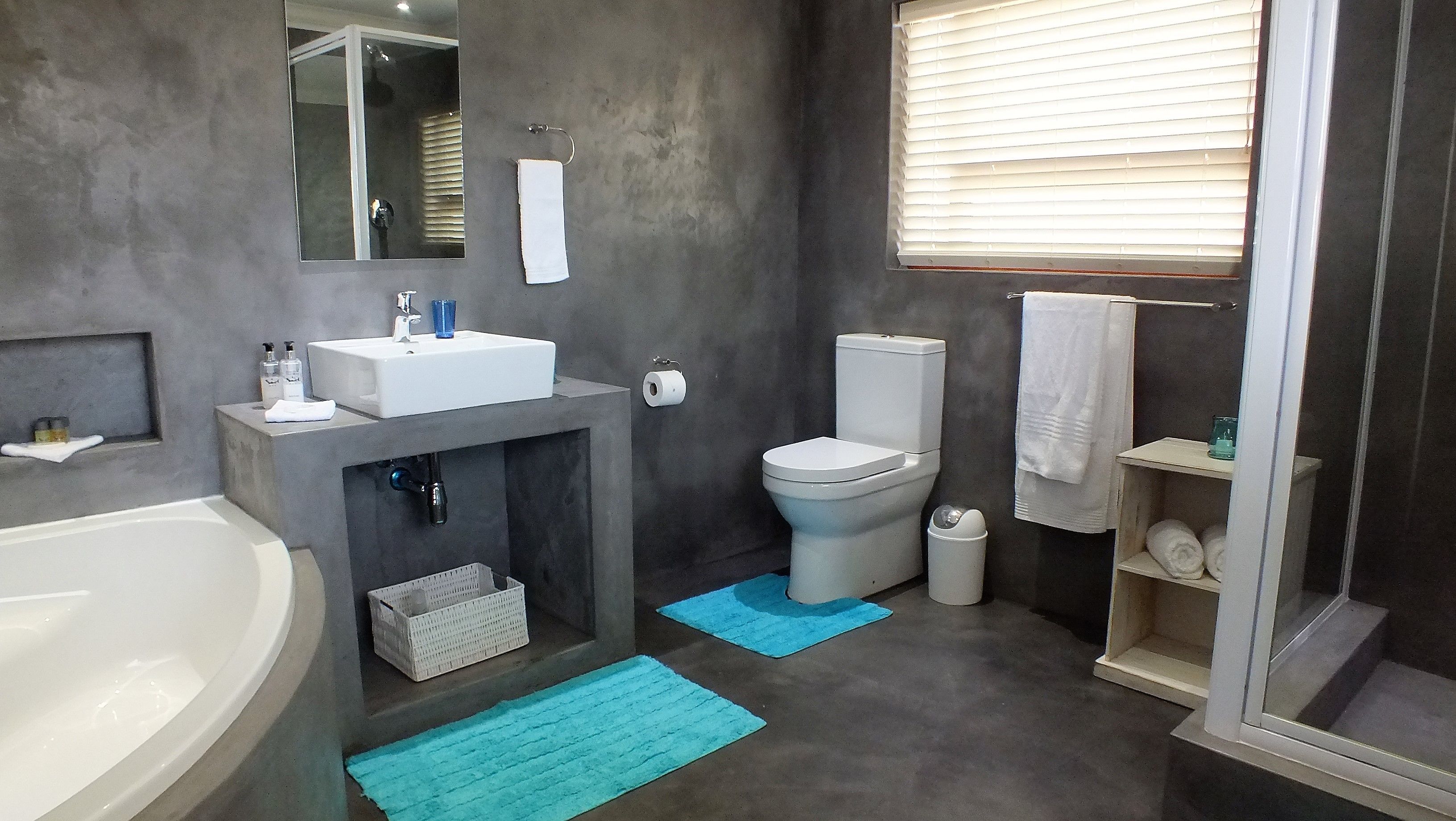 Une salle de bain moderne équipée d’une baignoire, d’un lavabo, de toilettes et d’une douche.