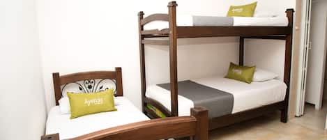 A bunk bed with a wooden frame and two pillows labeled "Ayenda Hotel".