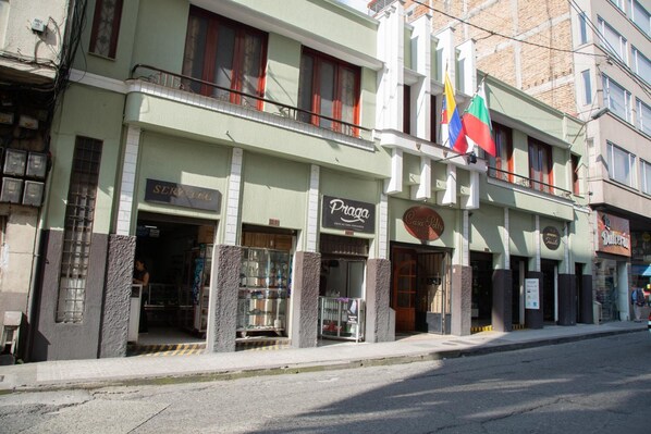 Un immeuble abritant plusieurs commerces, notamment une pharmacie et un restaurant.