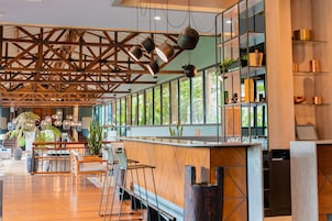 A spacious bar area with wooden flooring, a long counter, and hanging pendant lights.