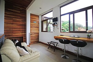 Una cocina moderna con una pared de acento de madera, un ventanal grande y una zona de bar con taburetes.