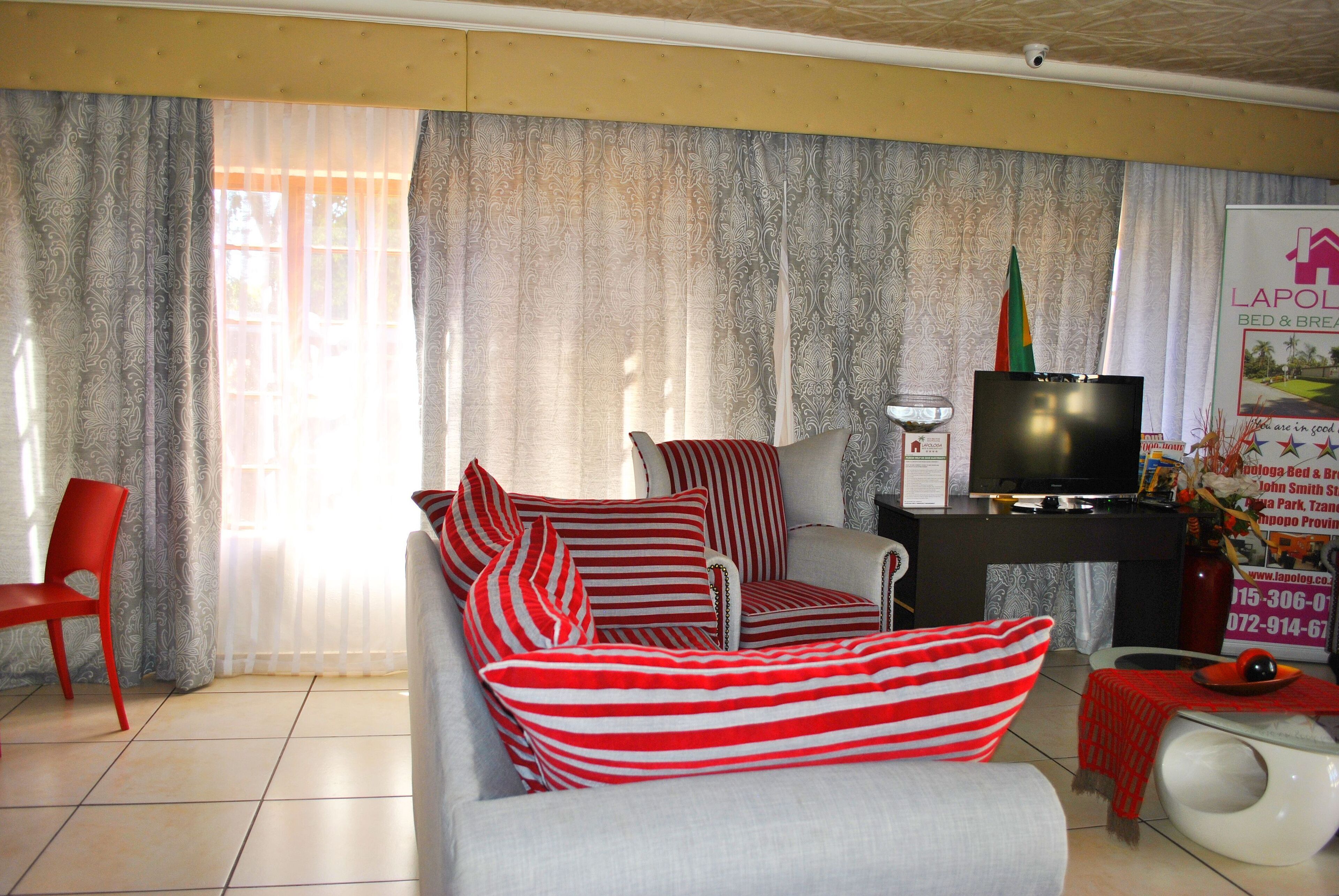 A living room with a sofa set, a television, and a small table with a decorative item.
