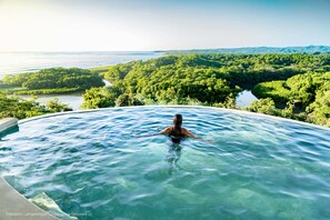 A person in a hot tub overlooking a lush landscape with a river and forest. - Hotel Boutique Lagarta Lodge (Nosara)