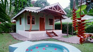 A small house with a porch and a swimming pool with flowers. - Ciudad Pérdida Ecolodge (Cahuita)