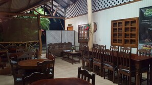 A restaurant with wooden furniture, a reception area, and a view of the outdoors. - Ciudad Pérdida Ecolodge (Cahuita)