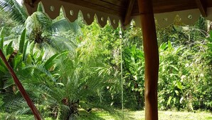 A hammock under a wooden structure with a view of a lush garden. - Ciudad Pérdida Ecolodge (Cahuita)