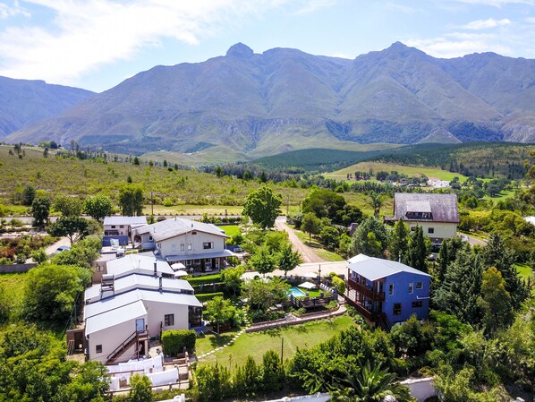 A residential area with houses, a swimming pool, and mountains in the background.