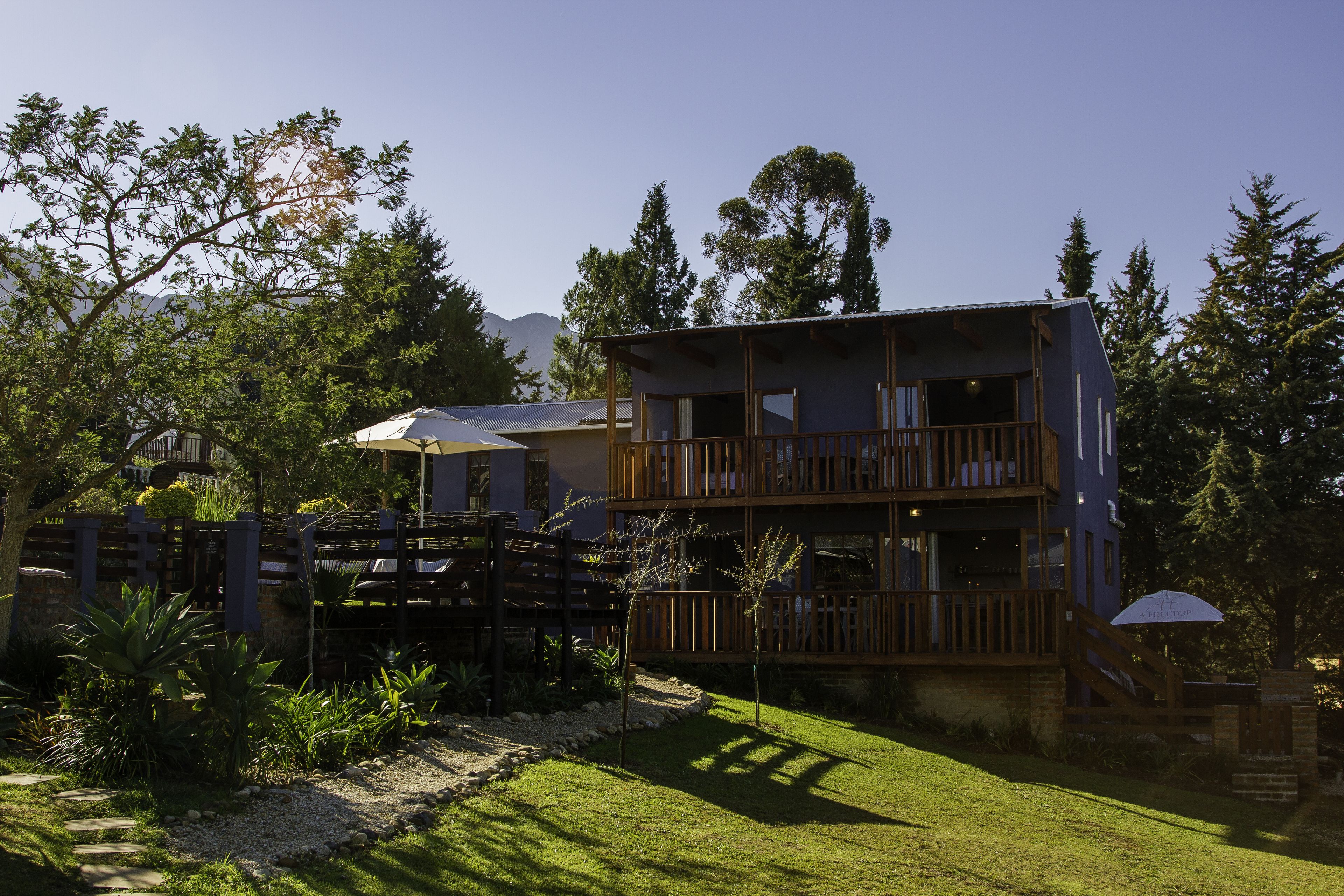 A two-story building with a wooden deck and a covered outdoor area.