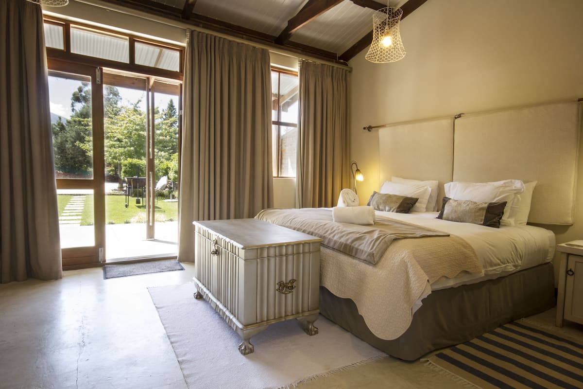 Een slaapkamer met een bed, nachtkastje en een kaptafel.