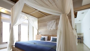 A bedroom with a canopy bed, wooden headboard, and a decorative wall piece. - Artemis Villa (Seminyak)