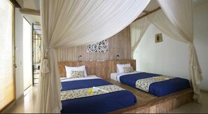 A room with two beds, each with a blue bedspread and white pillows, under a canopy. - Artemis Villa (Seminyak)