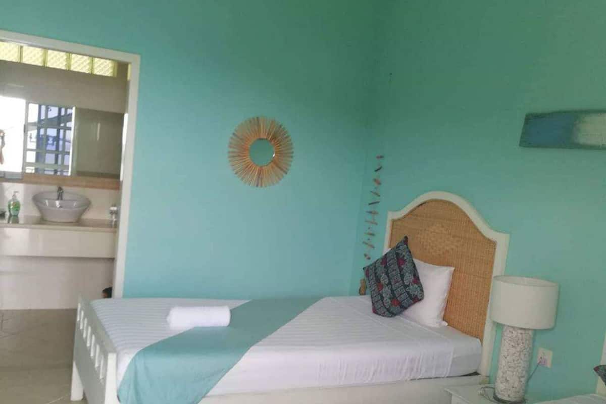 A room with two beds, a sink, and a mirror.