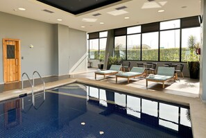 Una piscina techada, sillones reclinables de piscina