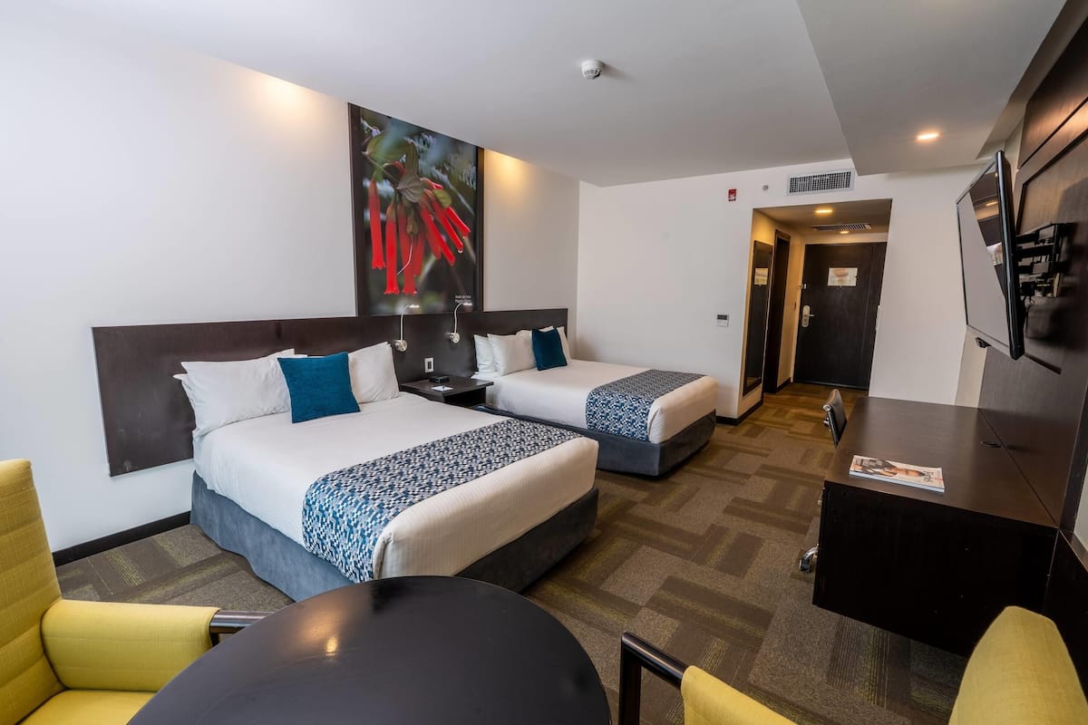 Una habitación de hotel con dos camas, un escritorio y una silla.