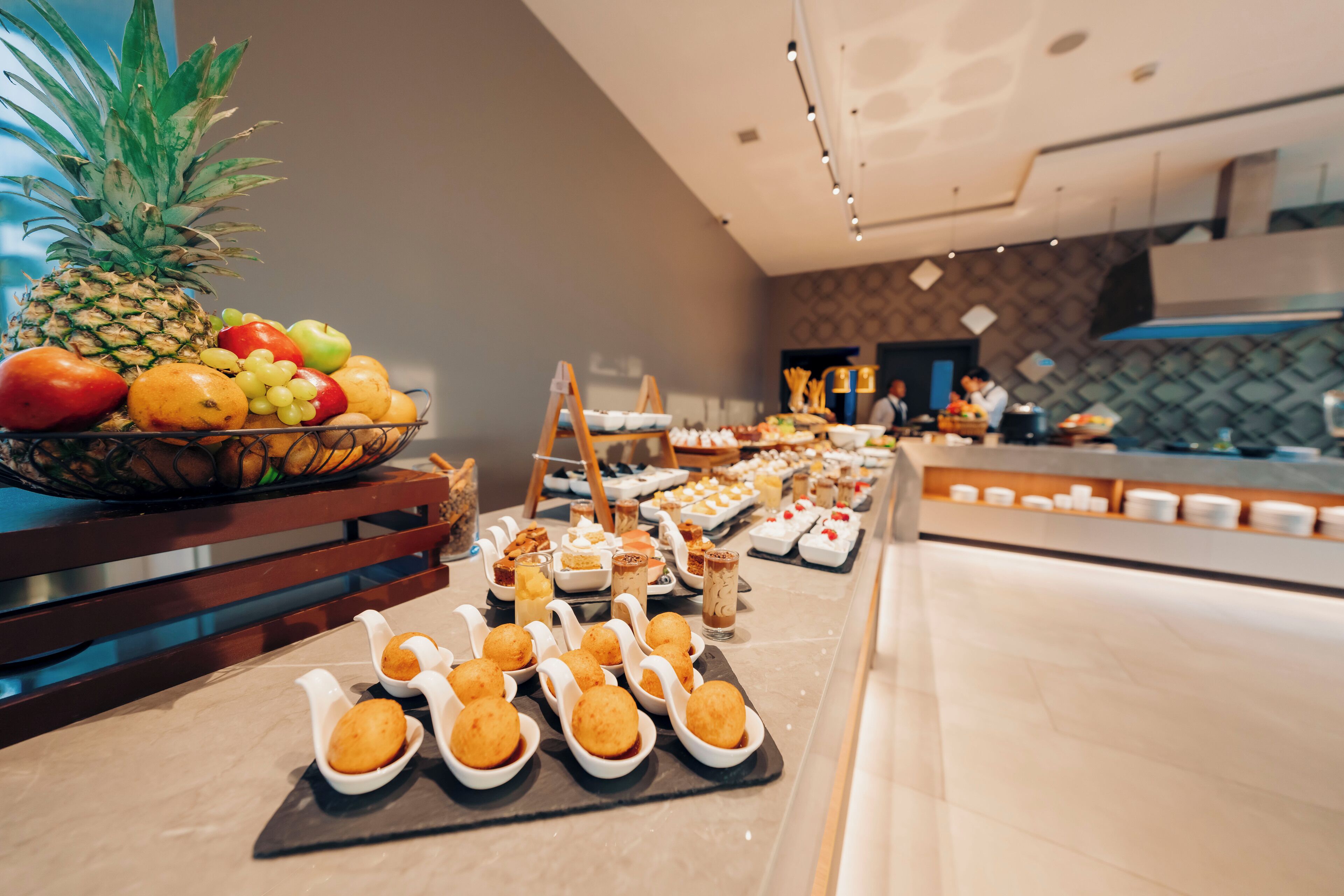 A buffet with various food items and a pineapple on the left.