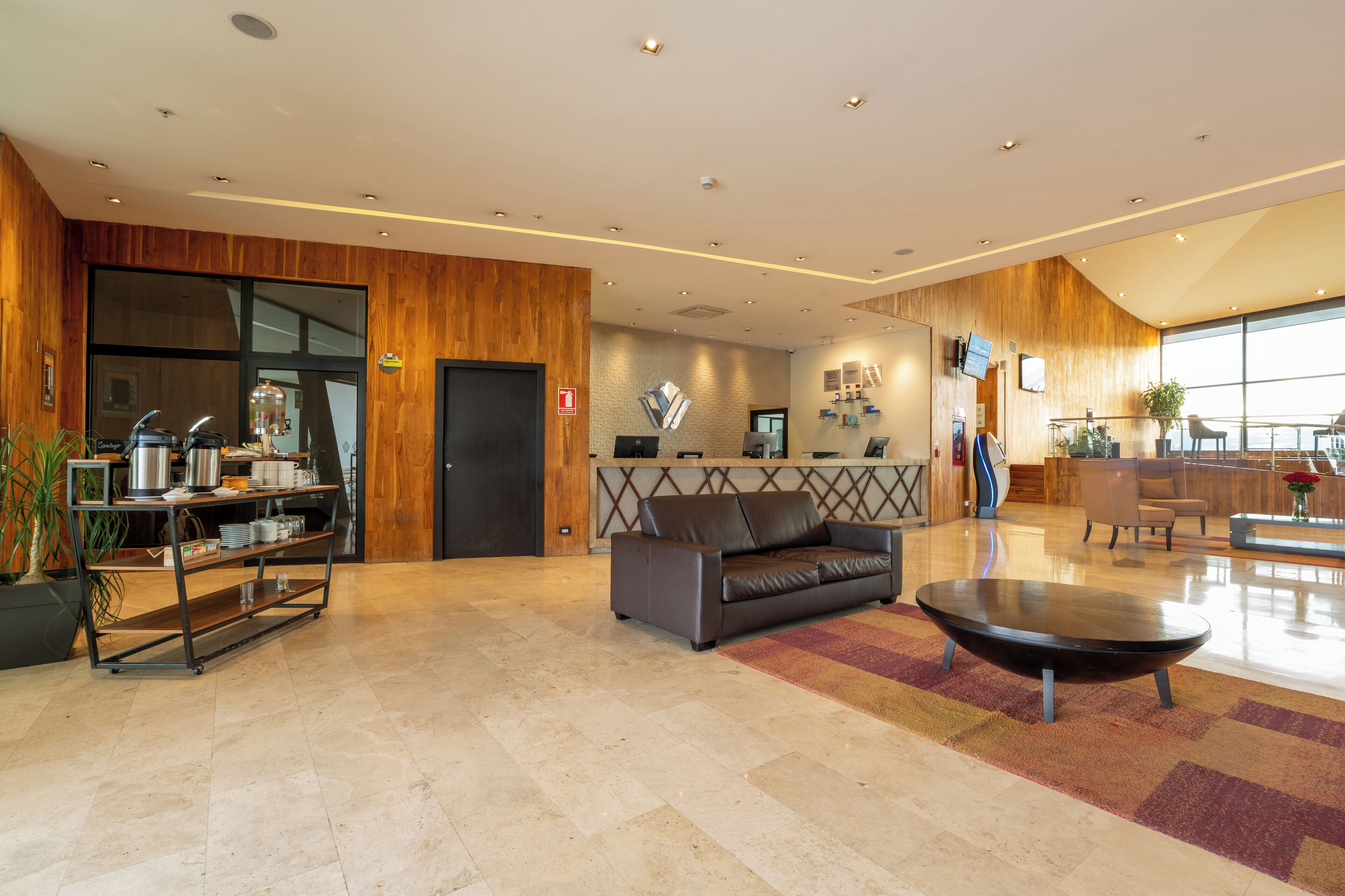 A spacious lobby with a reception desk, a leather sofa, and a coffee station.