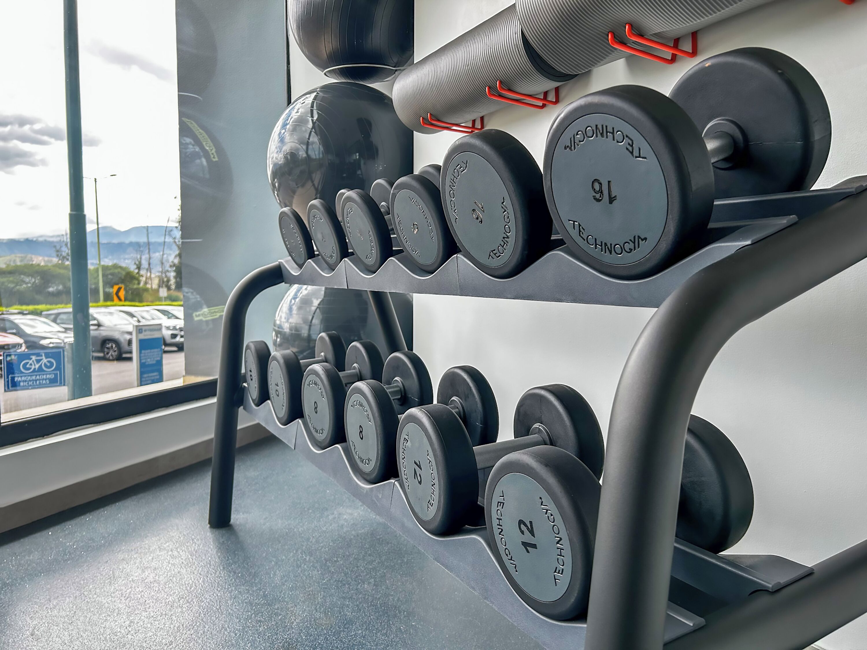 Un gimnasio con un banco de pesas y un espejo grande.