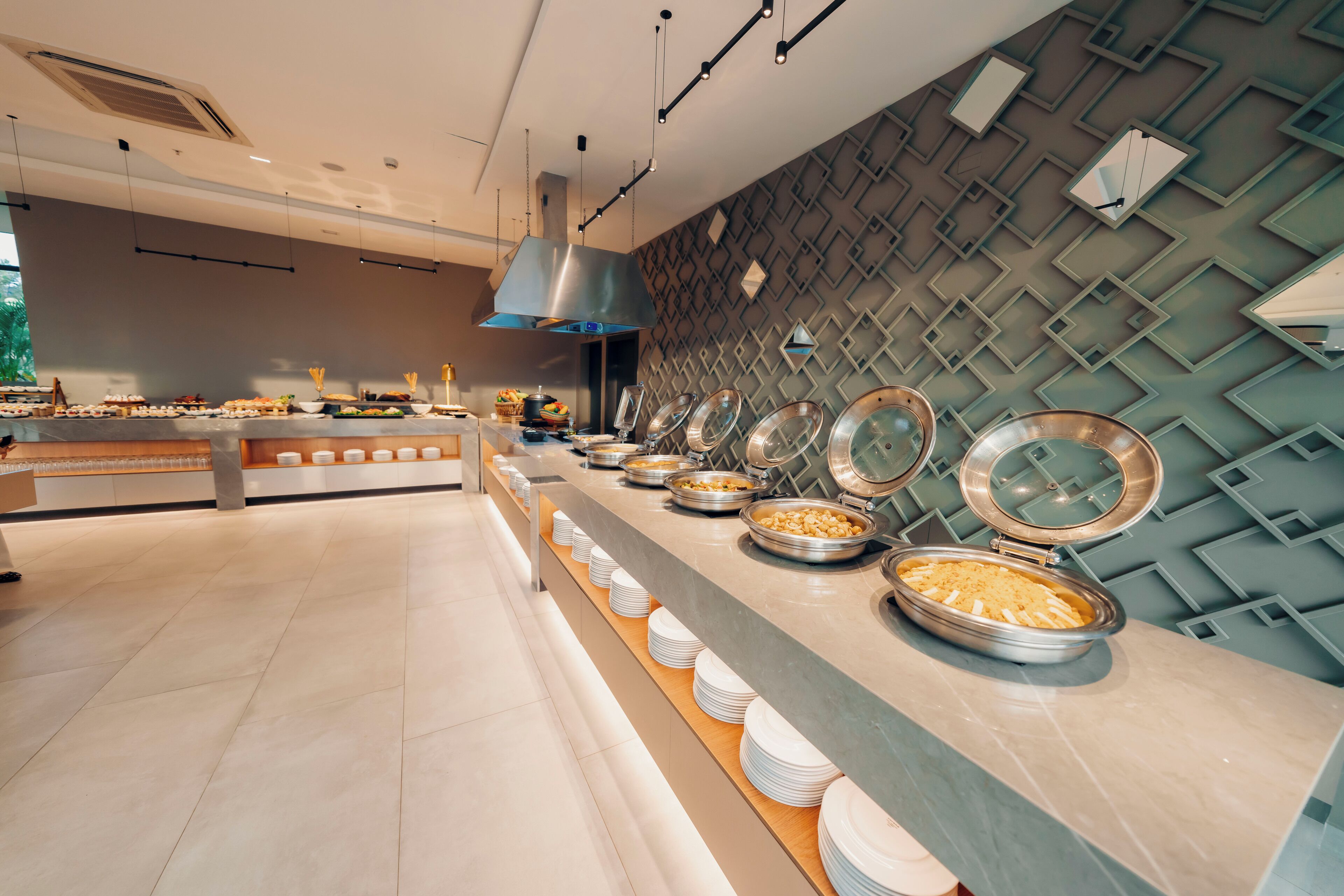 A buffet setup with various food items and utensils.