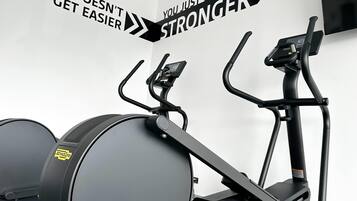 Un gimnasio con bicicletas estáticas y una pared con mensajes motivacionales.