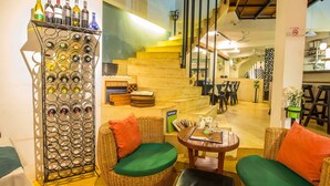 A cozy seating area with wicker furniture and a wine rack. - The Purple Mangosteen (Siem Reap)