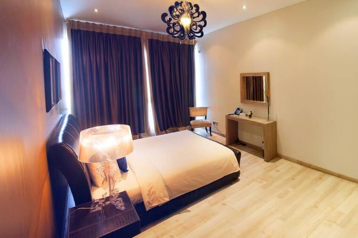 Ein Schlafzimmer mit Bett, Nachttisch, Lampe, Schreibtisch, Stuhl und Kleiderschrank.