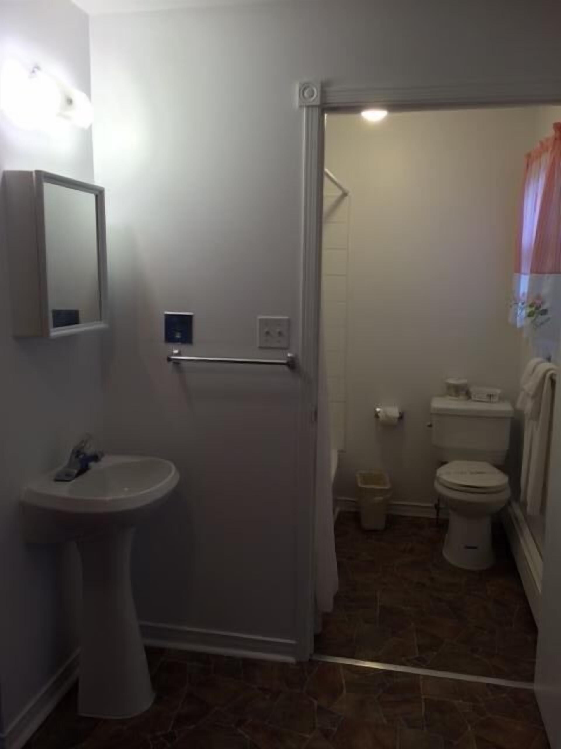 Un baño con lavamanos, inodoro y zona de ducha.