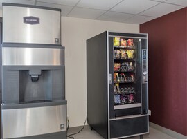 Máquina expendedora con diferentes aperitivos y un dispensador de agua.