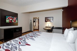 A hotel room with a bed, a desk, a chair, a television, and a microwave. - Red Roof Inn Vermillion - U of South Dakota (Vermillion)