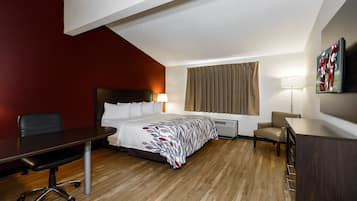Relax in a stylish room with a neatly made bed, desk, and flat-screen TV.