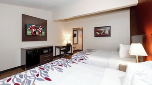A hotel room with two beds, a desk, a chair, and artwork on the walls. - Red Roof Inn Vermillion - U of South Dakota (Vermillion)