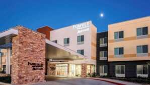 Een Fairfield Inn & Suites Marriott hotel met een gevel van baksteen, een overdekte ingang en een heldere lucht.